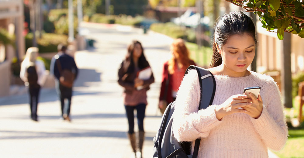 college student reading a marketing message on a smartphone